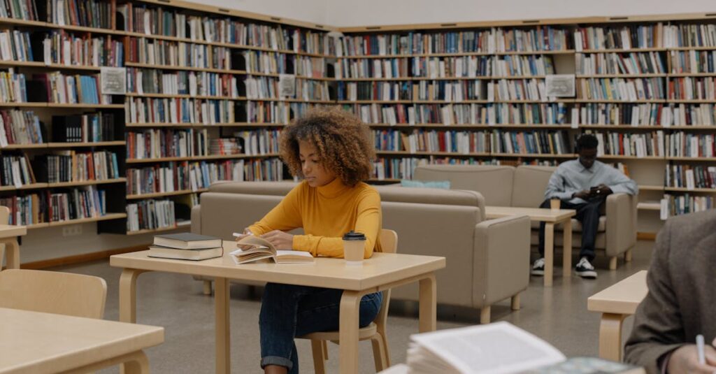 Students studying in a university library surrounded by bookshelves and tables.